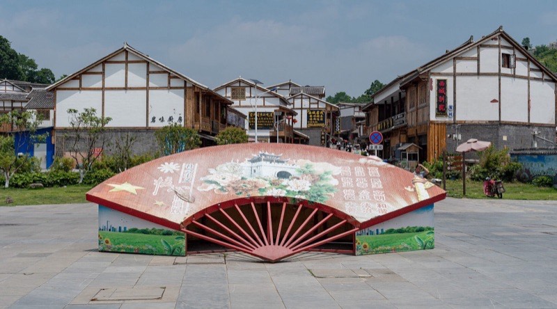 青岩古镇:广场上的折扇雕塑和白墙木楼